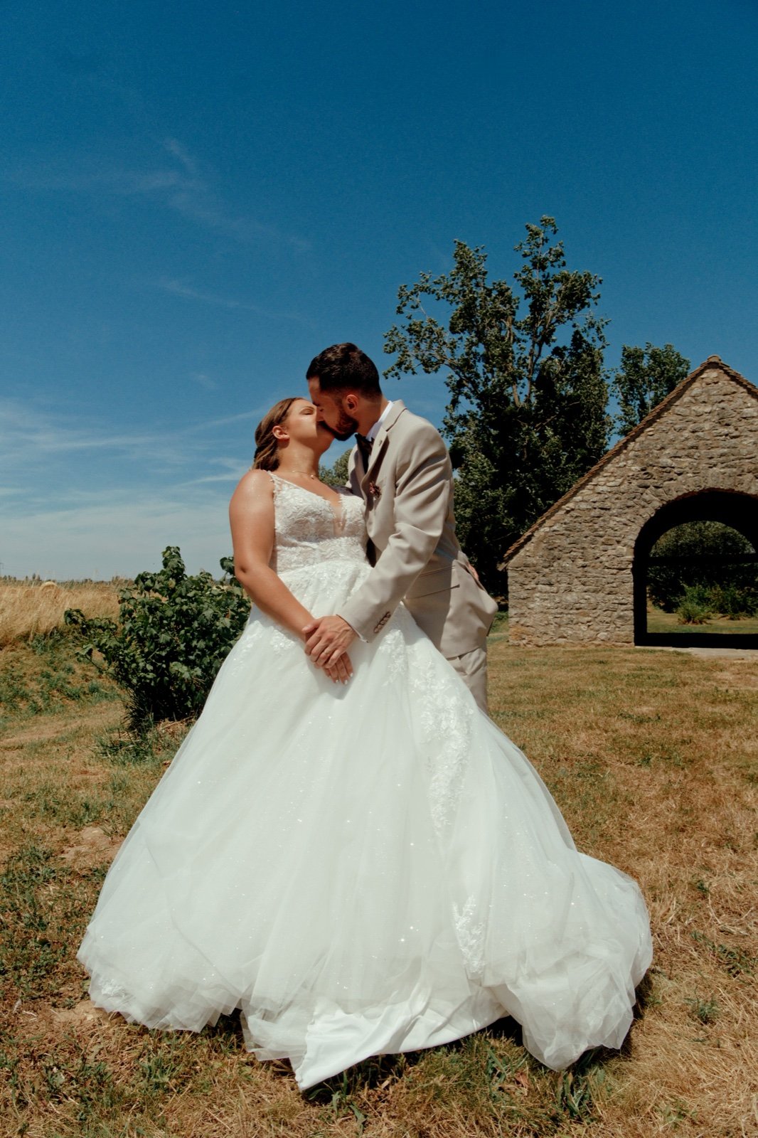 Couple de mariés devant une chapelle en pierre